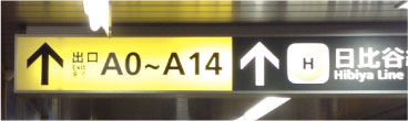 「出口 A0〜A14」という表記が描かれた、日比谷駅構内の出口看板の写真